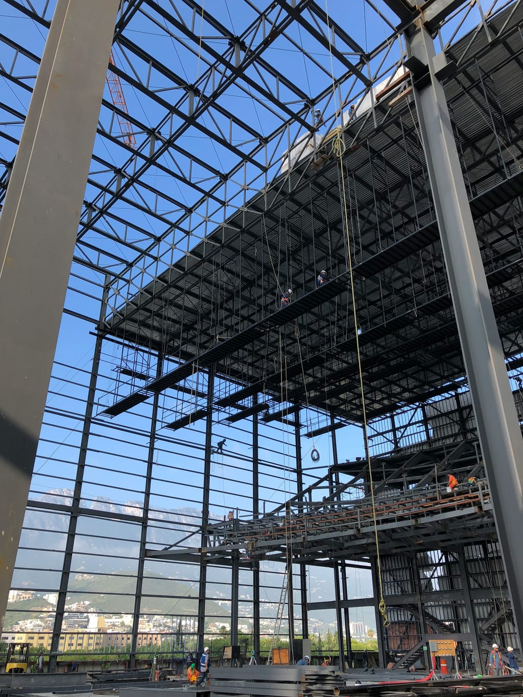 Crews erecting structural steel framing on a commercial construction site